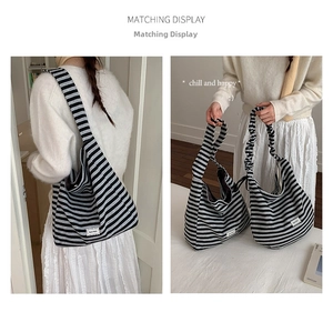Dual view of black and white striped canvas tote showing shoulder and handheld styling