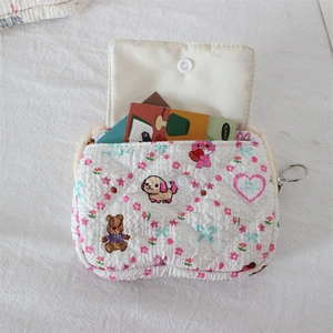Close-up of quilted coin purse with cartoon animals, snap pocket and silver ring zipper