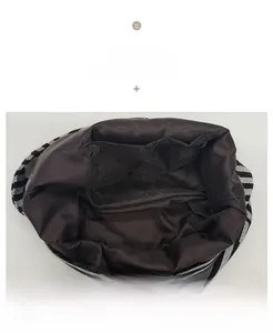 Detail view of the dark interior lining and inner pocket of the striped crossbody bag