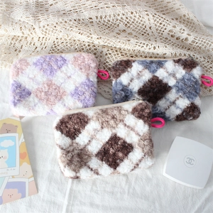 Three plush quilted makeup bags in colorful soft faux fur for travel organization