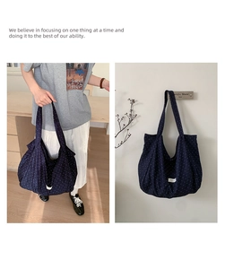 Detail of navy blue polka dot canvas tote bag featuring wide straps and minimalist label