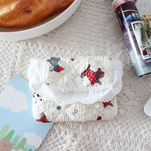 Detailed texture of quilted dog print coin purse with elegant white lace trim and button
