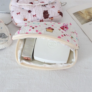 Detailed view of quilted makeup bag featuring cute pink rabbit and bear cartoon patterns