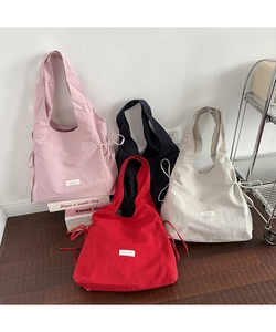 Detail showing various colors of nylon tote bags with drawstring design on side