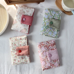 Detail of floral fabric pouches with cotton padding and colorful snap button closures