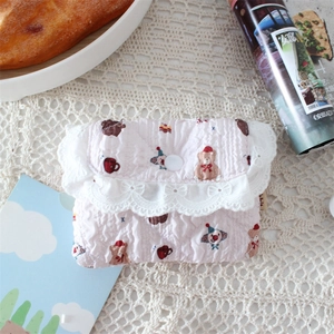 Detailed view of pink quilted coin purse with bear pattern and lace trim on vintage lace