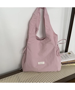 Detail of pink canvas tote bag with side drawstring ruching and brand logo patch