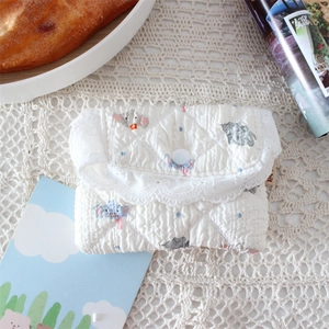 Detailed shot of white quilted coin purse with elephant pattern and lace trim