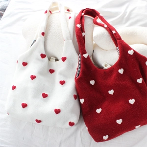 Detail of soft plush tote bag with embroidered hearts and magnetic buckle closure