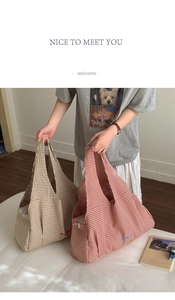 Detail of checkered canvas tote bags with embroidered text and zip closure for daily use