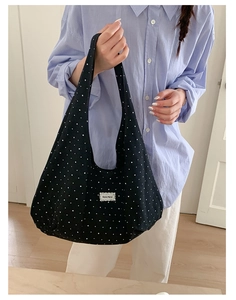 Detail of black polka dot canvas tote bag with Beyou Merci label and star pattern