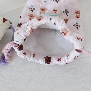 Detail of pink quilted drawstring storage bag with cartoon bear print and thick lining