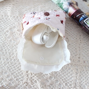 Detail of pink quilted mini storage bag with bear patterns and white lace trim