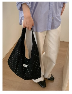 Detailed shot of large capacity black polka dot hobo bag on model for casual daily use