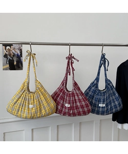 Detail of checkered tote bags in yellow, red, and blue with stylish bow knot handles