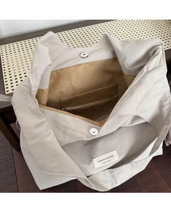 Interior detail of nylon tote bag with magnetic clasp, suede lining, and zipper pocket