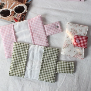 Detailed view of floral and plaid fabric handmade pouches with metal snap button closures