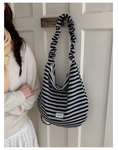 Close-up of a striped hobo bag with unique gathered scrunchie strap and lace label