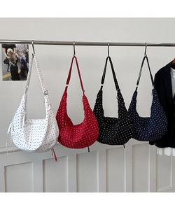 Close-up of polka dot canvas crossbody bags in white, red, black and navy blue