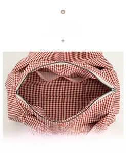 Detail view of red gingham tote bag interior featuring zipper closure and double slip pockets