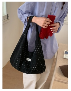 Detailed shot of black polka dot canvas tote bag with Beyou Merci lace label