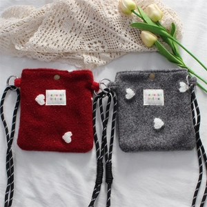Close-up of mini plush shoulder bags with heart detail and woven rope strap