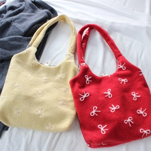 Chic tote bag with white bow embroidery and red wool texture shown in top-down view