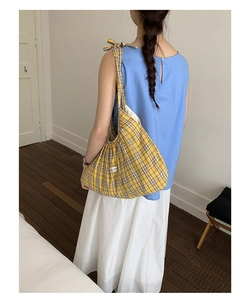 Detail of yellow checkered tote bag featuring a bow shoulder strap and side cloth label