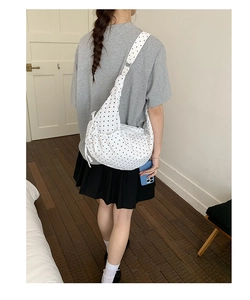 Detailed back view of white polka dot crossbody bag with stylish shoulder knot detail