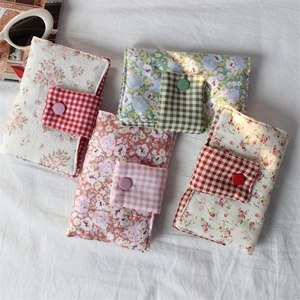 Detailed view of floral and plaid fabric book covers with decorative button closures