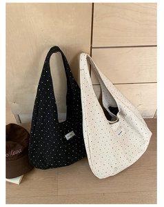 Close-up of canvas shoulder bags featuring polka dot and star patterns with fabric tags