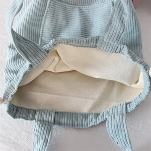 Close-up of light blue corduroy fabric texture and cream canvas interior lining detail
