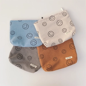 Corduroy polka dot cosmetic bags in four colors with minimalist smiley face pattern