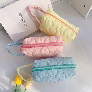 Three quilted floral cosmetic bags in pastel yellow, pink and blue with top handles
