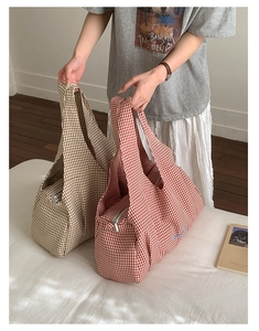 Close-up of stylish plaid tote bag showing soft fabric texture and secure zipper closure