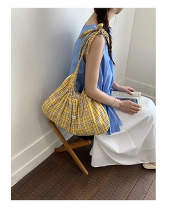 Detail of a plaid hobo bag with a side bow knot strap in Korean aesthetic style