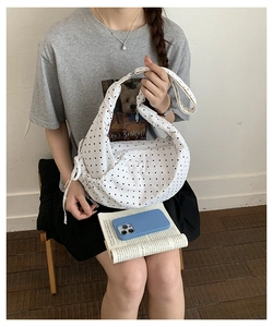 Detailed view of white polka dot hobo bag showing soft fabric texture and pleated design