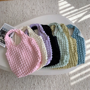 Minimalist popcorn fabric tote bags in various pastel colors with textured bubble pattern