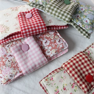 Close-up of floral fabric book covers with quilted cotton padding and snap button closures