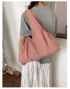 Detail of red checkered canvas tote bag with blue GoodThing embroidery and wide shoulder strap