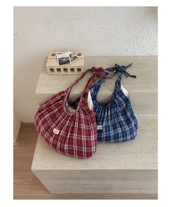 Detail of red and blue checkered tote bags with pleated fabric and bow shoulder straps