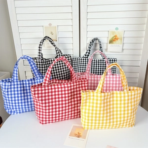 Close-up of colorful checkered canvas tote bags in blue, red, yellow, and pink colors