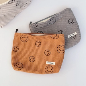 Corduroy pouch set with smiley faces in mustard, grey, and off-white colors
