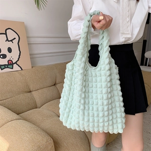 Detail of mint green bubble texture fabric and wavy handle on a soft canvas tote bag