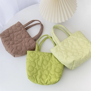 Quilted floral handbags in brown and green colors displayed on a white surface
