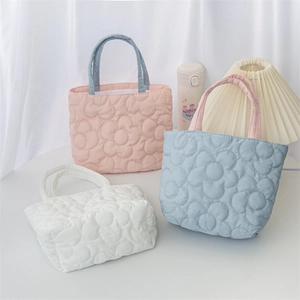 Detailed view of quilted tote bags featuring floral patterns in pink, blue, and white colors