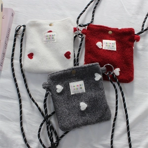 Detailed view of plush mini crossbody bags with heart decor and braided straps