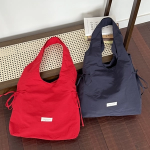 Red and navy blue large nylon tote bags with drawstring sides and minimalist design