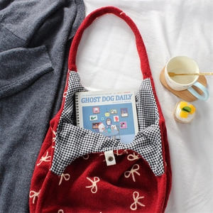 Detail of red knitted tote bag with bow embroidery and checkered lining with magnetic snap