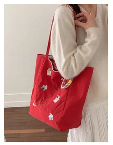 Détail du sac cabas en toile rouge avec broderie animalière et doublure rayée